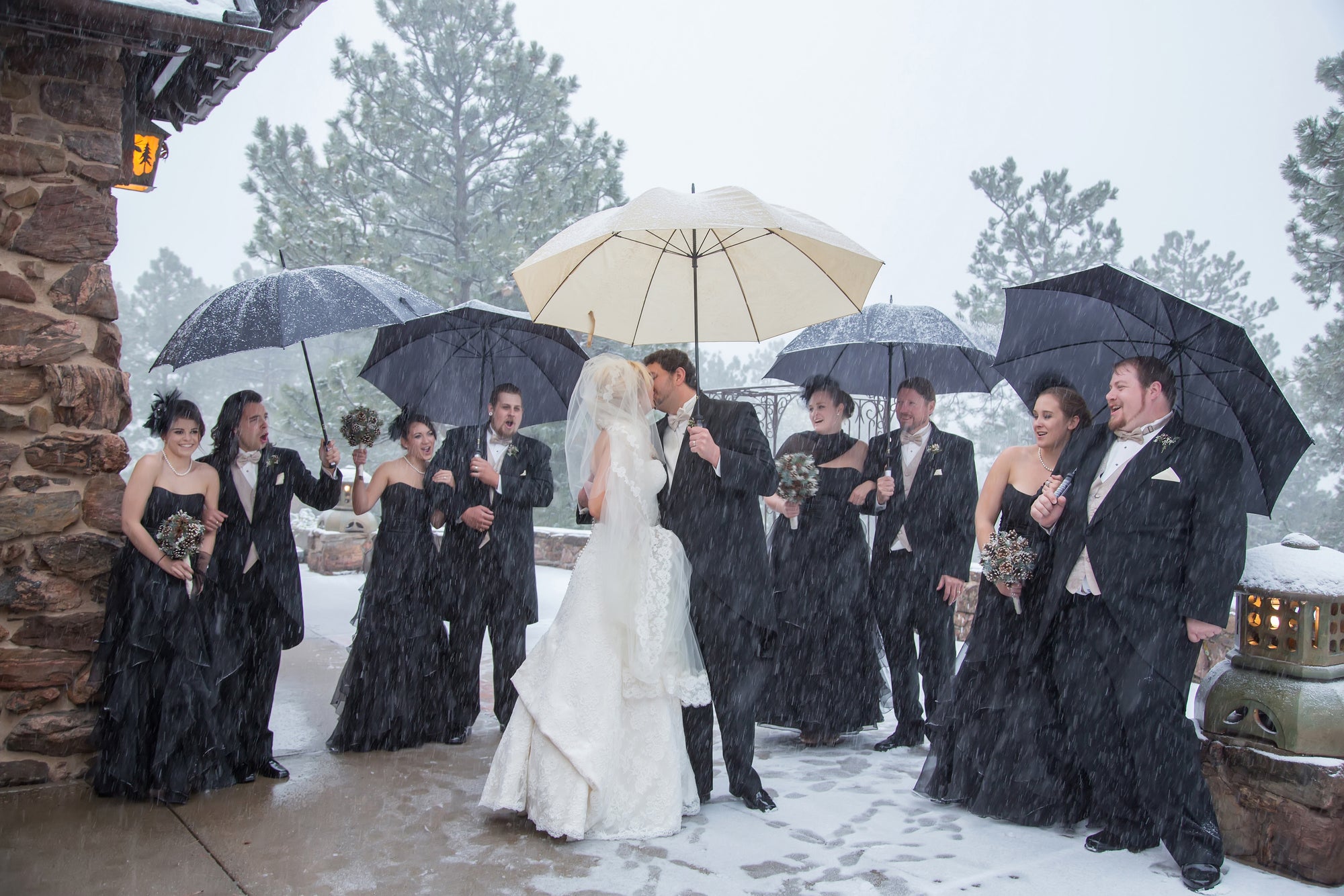 Umbrellas protecting wedding party from snow. Courtesy Allee Photography.