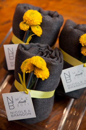 Gray shawls with yellow flowers wrapped with tags