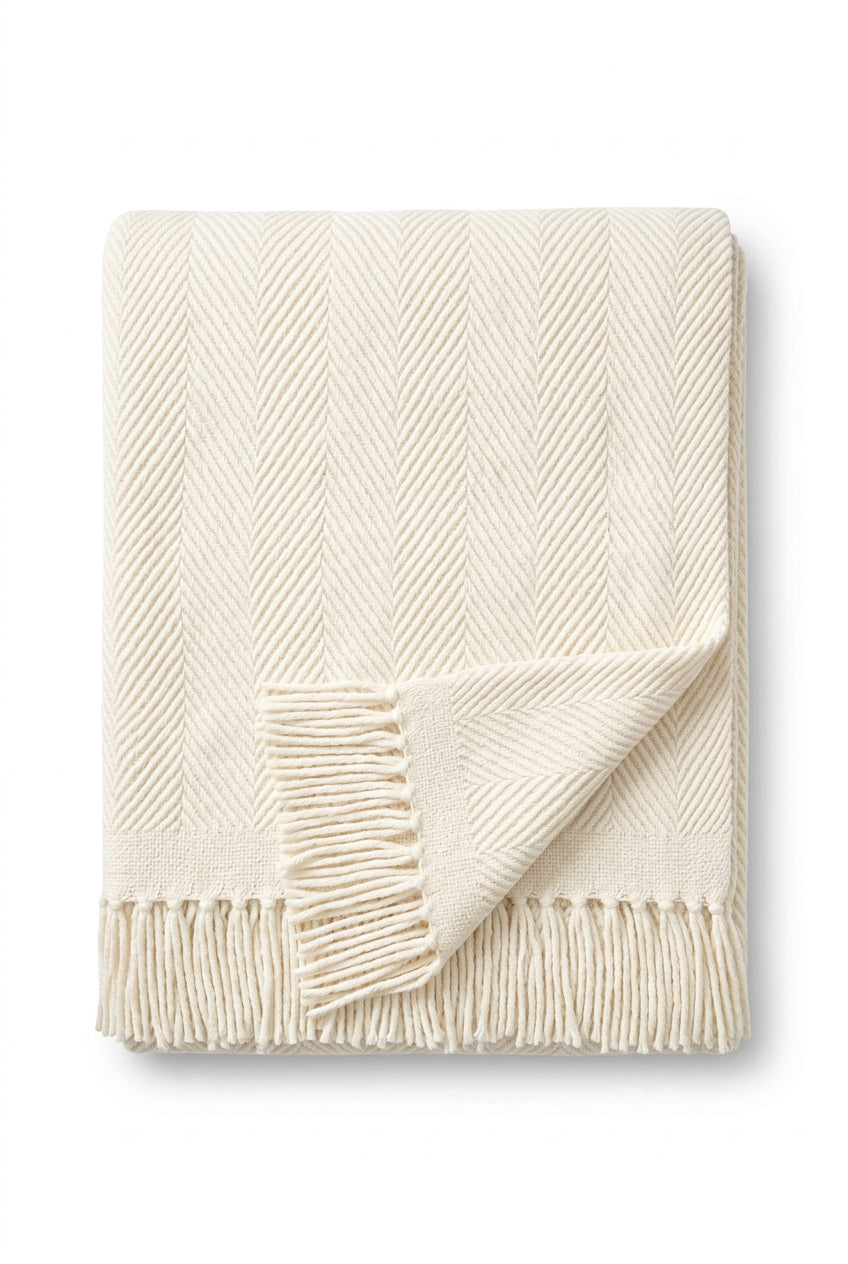 an ivory herringbone throw blanket with fringe