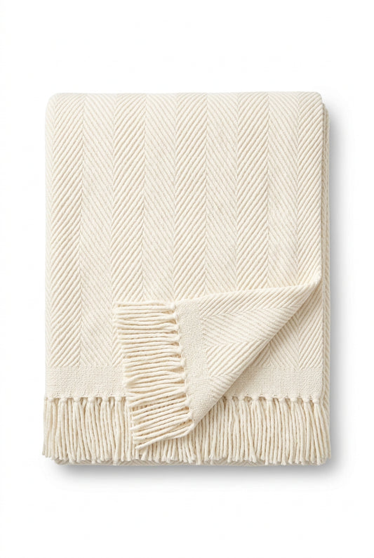 an ivory herringbone throw blanket with fringe